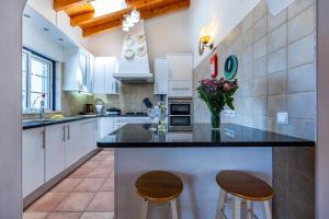 アルジェズールにあるCasa Maresiaの白いキャビネット付きのキッチン、カウンター(2つのスツール付)