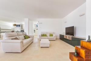 ein Wohnzimmer mit 2 weißen Sofas und einem TV in der Unterkunft Villa Cesira by Perle di Puglia in Muro Leccese