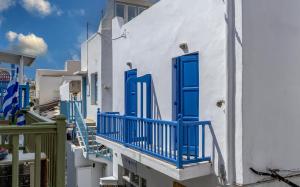 a group of white buildings with blue doors and stairs at Manto Hotel in Mikonos