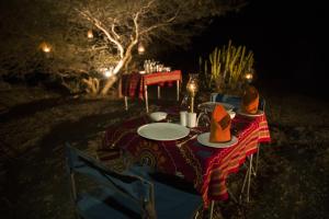 a table with plates and hats on top of it at Amritara Jawai Resort in Pāli