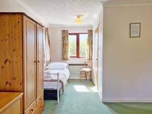 Bramley Cottage في Charlton: غرفة نوم صغيرة بها سرير ونافذة