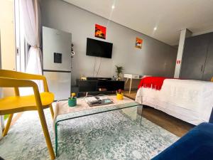 a living room with a bed and a tv at Cozy condo in the heart of Maboneng in Johannesburg