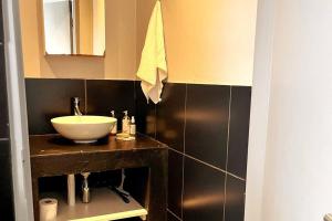 a bathroom with a sink and a mirror at Cozy condo in the heart of Maboneng in Johannesburg