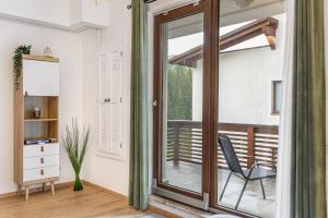 a room with a glass door and a chair on a balcony at Clabucet Alpin Studio in Predeal