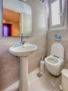 a bathroom with a toilet and a sink and a mirror at Manto Hotel in Mýkonos City