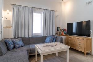 sala de estar con sofá y TV de pantalla plana en Manto Hotel, en Mykonos ciudad