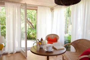 a living room with a table and chairs and a window at Bungalow mit Wintergarten in Seehof