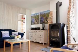 a living room with a fireplace and a blue couch at Bungalow mit Wintergarten in Seehof