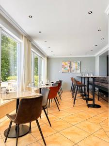 a dining room with tables and chairs and windows at Seespitz Gästehaus in Herrsching am Ammersee