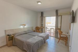 1 dormitorio con 1 cama grande y balcón en Hotel Tres Jotas Conil, en Conil de la Frontera
