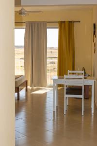 einen weißen Tisch und Stuhl in einem Zimmer mit Fenster in der Unterkunft Beauty Plaza Apartaments in Santa Maria