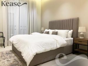 a bedroom with a large bed with white sheets at Kease Tawun A1-8 Royal touch Balcony GZ41 in Riyadh