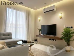 a living room with a couch and a tv at Kease Tawun A1-8 Royal touch Balcony GZ41 in Riyadh