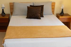 una camera da letto con letto, lenzuola e cuscini bianchi di Beauty Plaza Apartaments a Santa Maria