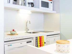 uma cozinha branca com um lavatório e um micro-ondas em Appartement Les Arcs 1800, 2 pièces, 5 personnes - FR-1-346-355 em Arc 1800