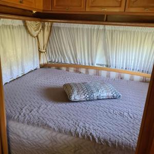 a bed with a pillow sitting on top of it at Vrijheid caravan in Wallenborn