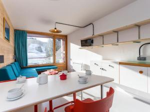 a kitchen and living room with a table and chairs at Studio Les Arcs 1800, 1 pièce, 5 personnes - FR-1-346-366 in Arc 1800
