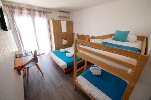 a small room with two bunk beds and a table at Sunrise Beach Hotel in Gruissan