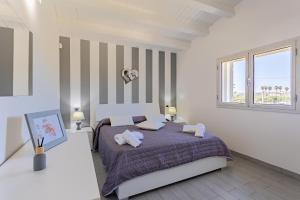 a white bedroom with a bed with two pillows at Torre del mare in Menfi +31 photos