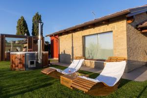 two lounge chairs on a lawn in front of a house at Casa Grazia in San Giorgio di Pesaro