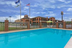 a swimming pool in front of a building with flags at Days Inn by Wyndham Franklin in Franklin