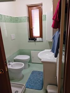 ein Badezimmer mit einem Waschbecken, einem WC und einem Spiegel in der Unterkunft Cappuccini Guest House in San Giovanni in Fiore