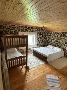 1 dormitorio con 2 literas y techo de madera en 3 VELLEZERIT DOCI GUEST HOUSE, en Fushë-Lurë