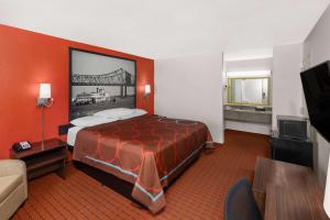 une chambre d'hôtel avec un lit et une photo de pont dans l'établissement Super 8 by Wyndham Baton Rouge/I-10, à Bâton-Rouge