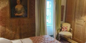 Intres的住宿－Bérard，一间卧室配有一张床、一幅画和一把椅子