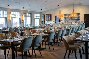 une rangée de tables et de chaises dans un restaurant dans l'établissement Hotel Grimsborgir by Keahotels, à Ásborgir
