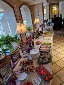 długi stół z wieloma talerzami żywności w obiekcie Motelis Smagratis Kretinga w mieście Kretynga