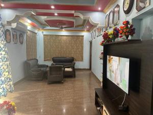 - un salon avec une télévision et une salle d'attente dans l'établissement Stunning 4-Bedroom Family Haven, à Patna