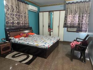 - une chambre avec un lit et une chaise dans l'établissement Stunning 4-Bedroom Family Haven, à Patna