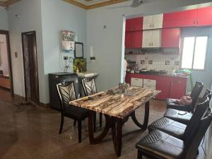 une cuisine avec une table en bois et des chaises noires dans l'établissement Stunning 4-Bedroom Family Haven, à Patna