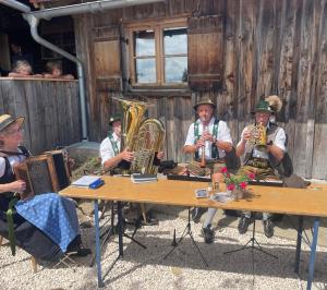 een groep mensen die aan een tafel zitten en instrumenten bespelen bij Ferienwohnung Drei Seen in Blaichach