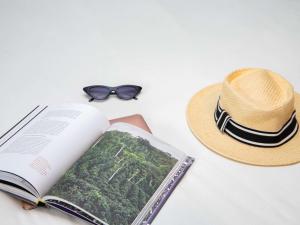 um chapéu e um livro e um chapéu e óculos de sol em Ibis Styles Abidjan Marcory em Abidjan