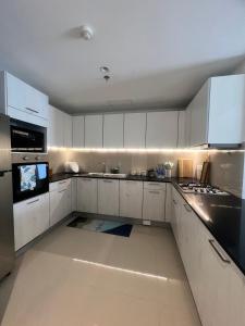 eine große weiße Küche mit weißen Schränken und Geräten in der Unterkunft 2 Bedroom Apartment in Sri Jayewardenepura Kotte