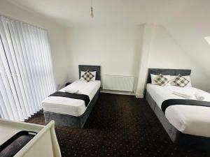 ロンドンにあるBlack Horse Inn Hotelのベッド2台と窓が備わるホテルルームです。