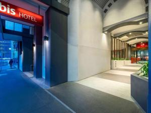 un edificio con una señal de hotel de autobús en el lateral. en ibis Melbourne Hotel and Apartments en Melbourne