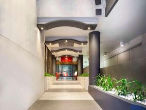un pasillo en un edificio con plantas en ibis Melbourne Hotel and Apartments en Melbourne