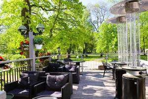 a patio with tables and chairs in a park at Vänerport Stadshotell i Mariestad in Mariestad