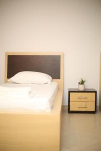 uma cama com uma cabeceira de madeira e uma mesa de cabeceira em TekB Rooms & Apartments em Vlorë