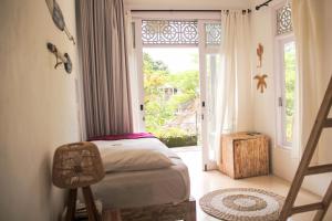 a bedroom with a bed and an open door at Mondo Surf Village in Canggu
