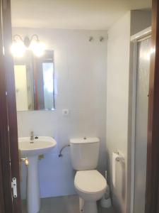 a white bathroom with a toilet and a sink at 3 bedrooms apartement at Isla Cristina 700 m away from the beach with balcony in Isla Cristina