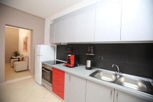 uma cozinha com um lavatório e um frigorífico branco em TekB Rooms & Apartments em Vlorë