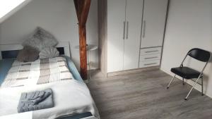 - une chambre avec un lit et une chaise dans l'établissement Bochum Apart Doppelzimmer mit Gemeinschaftsbad, à Bochum