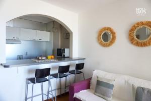 un salon avec un comptoir et une cuisine avec des tabourets dans l'établissement Brisa Marina Apartamento, à Empuriabrava