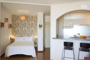 Cet appartement comprend une chambre avec un lit blanc et une cuisine. dans l'établissement Brisa Marina Apartamento, à Empuriabrava