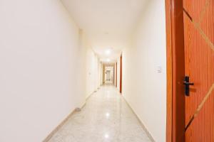 un pasillo vacío con una puerta abierta y una pared blanca en FabHotel The Luxe Inn, en Nueva Delhi