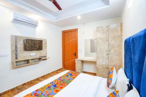 una camera con letto, TV e camino di FabHotel The Luxe Inn a Nuova Delhi